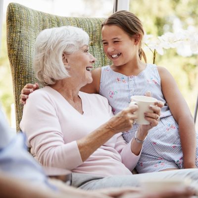 Granddaughter Visiting Grandparents In Lounge Of Retirement Home